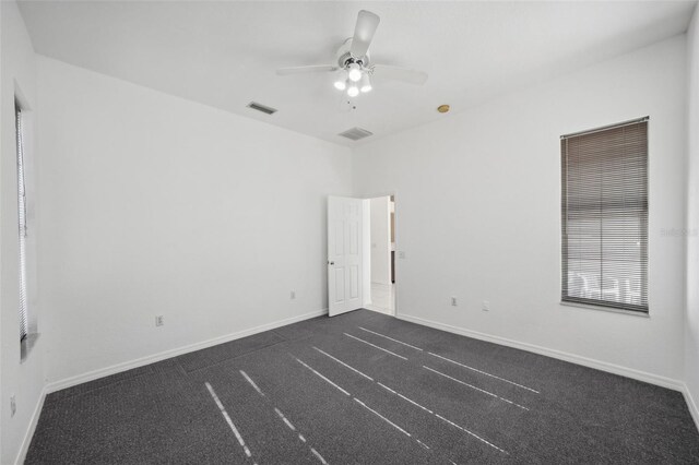 carpeted spare room featuring ceiling fan