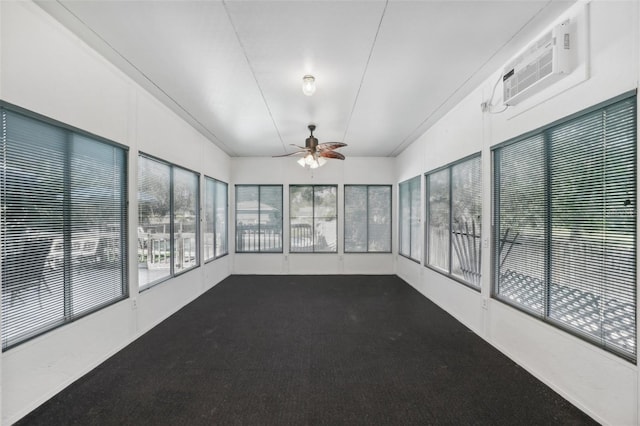 unfurnished sunroom featuring ceiling fan, a wall mounted AC, and vaulted ceiling