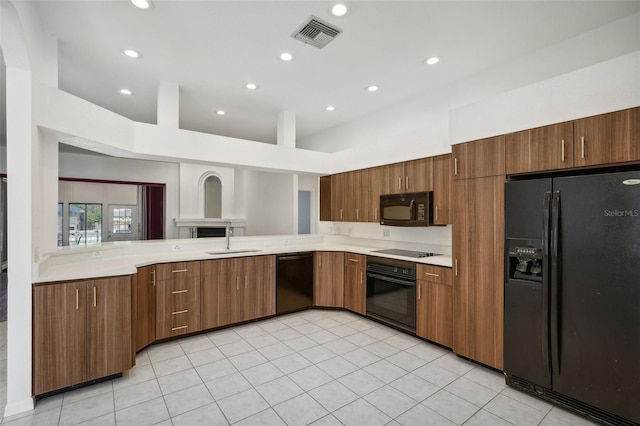 kitchen featuring sink, light tile patterned floors, and black appliances