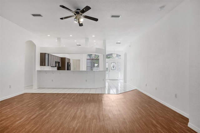 unfurnished living room featuring ceiling fan and light hardwood / wood-style flooring