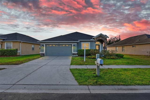 view of front of home with a garage and a yard