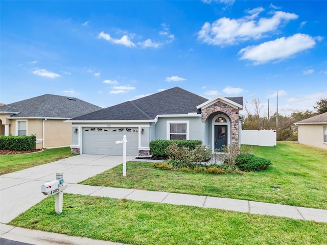 single story home with a garage and a front lawn