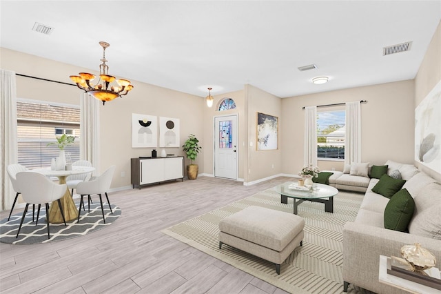 living room featuring light hardwood / wood-style flooring and an inviting chandelier