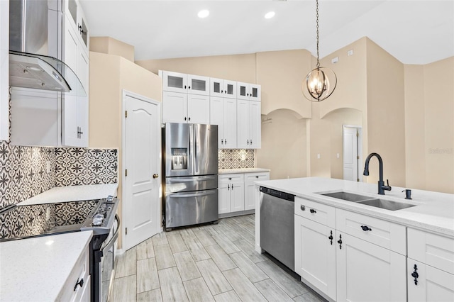 kitchen with white cabinetry, sink, stainless steel appliances, lofted ceiling, and exhaust hood