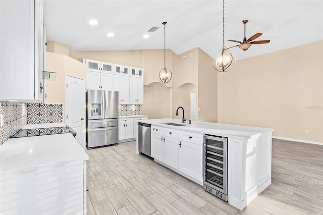 kitchen with sink, white cabinetry, stainless steel appliances, and wine cooler