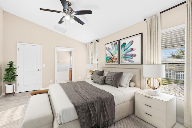 bedroom with ensuite bathroom, ceiling fan, light hardwood / wood-style floors, and lofted ceiling