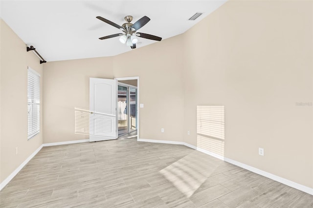 empty room featuring ceiling fan, vaulted ceiling, and light wood-type flooring