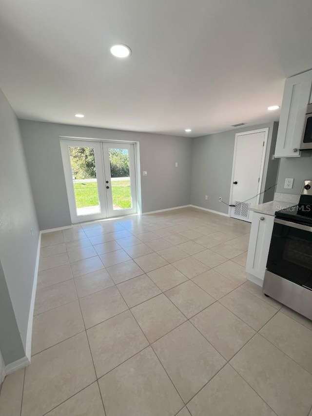 kitchen featuring white cabinetry, french doors, stainless steel appliances, light stone counters, and light tile patterned floors