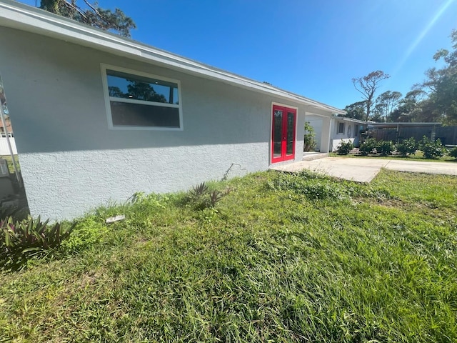 735 Bertrend St, Englewood, FL 34223 - view of exterior entry featuring stucco siding, a yard, french doors, and a patio area