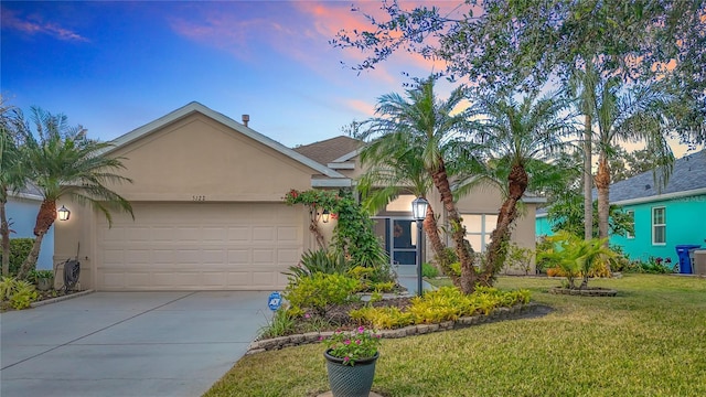 ranch-style home featuring a garage and a yard