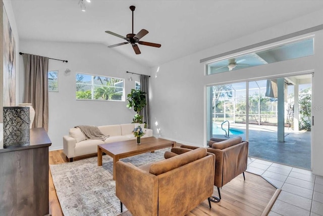 living room featuring ceiling fan, lofted ceiling, and light tile patterned floors