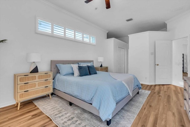 bedroom with a closet, hardwood / wood-style flooring, ceiling fan, and ornamental molding