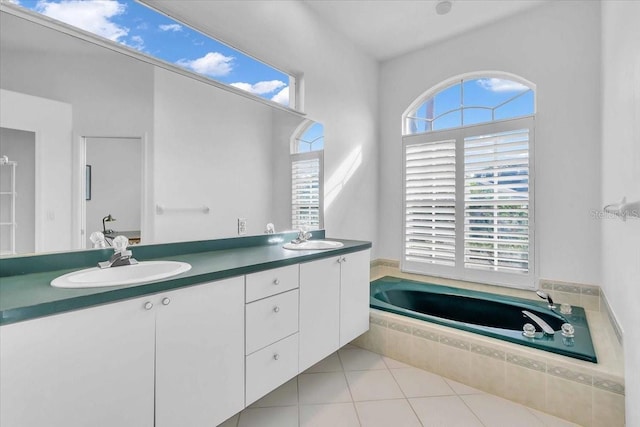 bathroom with tile patterned floors, tiled bath, and vanity