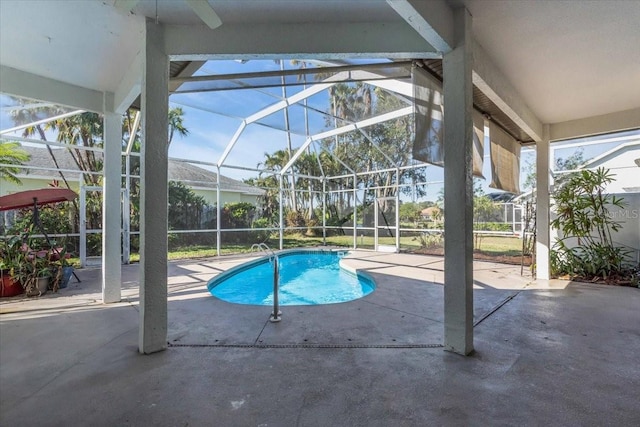 view of pool with glass enclosure and a patio area