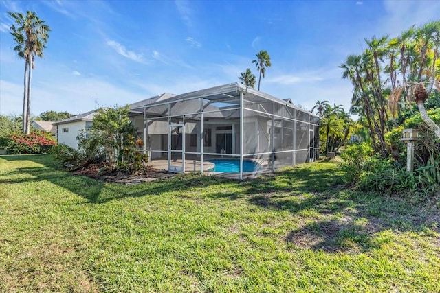 rear view of house featuring a lanai and a lawn