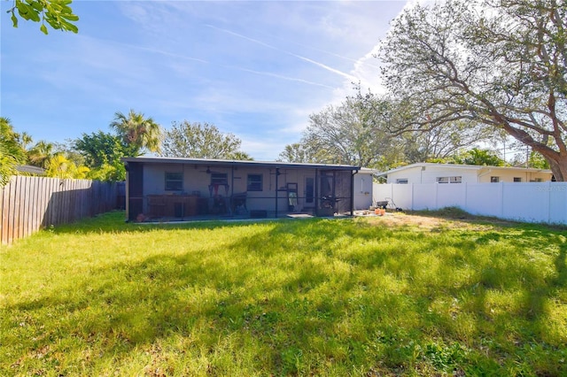 back of house with a lawn and a sunroom