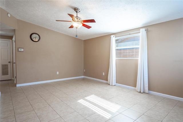 unfurnished room featuring ceiling fan, light tile patterned floors, and a textured ceiling