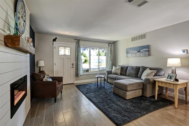 living room featuring a large fireplace and hardwood / wood-style floors