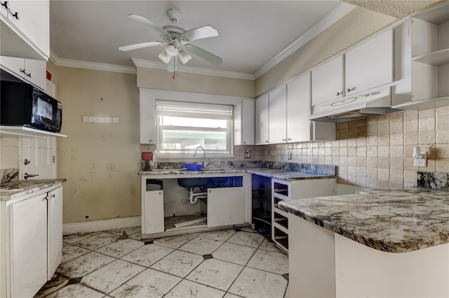 kitchen with black microwave, under cabinet range hood, white cabinets, ornamental molding, and decorative backsplash