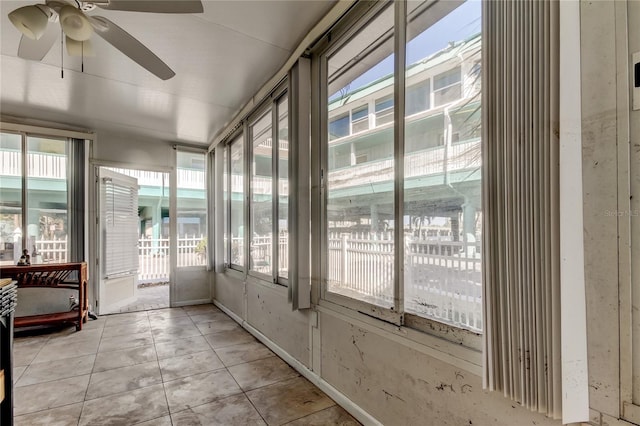 unfurnished sunroom with ceiling fan