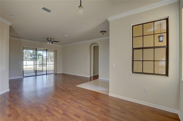 empty room with ceiling fan, wood-type flooring, and ornamental molding