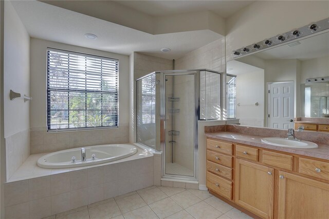 bathroom with tile patterned floors, vanity, and shower with separate bathtub