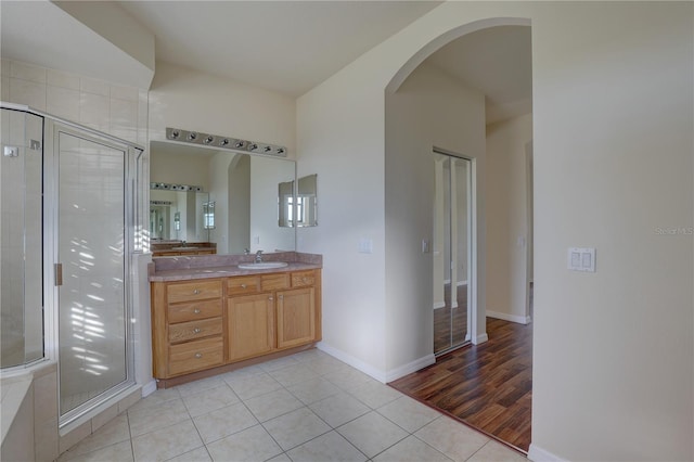 bathroom featuring vanity, hardwood / wood-style flooring, and a shower with door