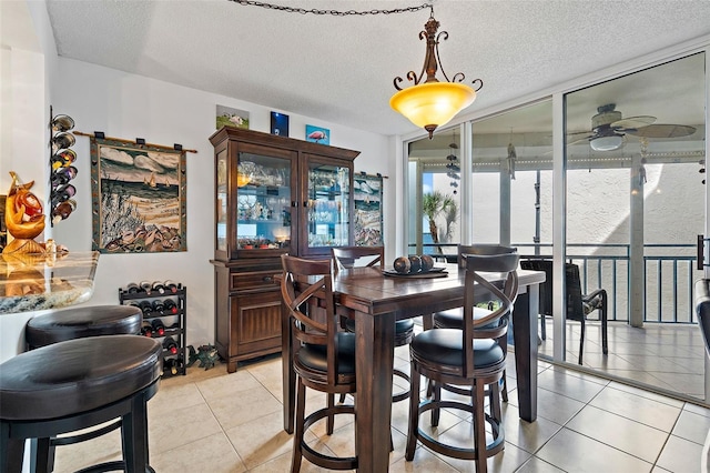 dining room with light tile patterned floors, a textured ceiling, and ceiling fan