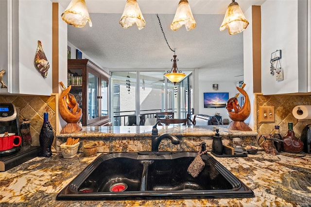 kitchen featuring decorative backsplash, sink, and a textured ceiling