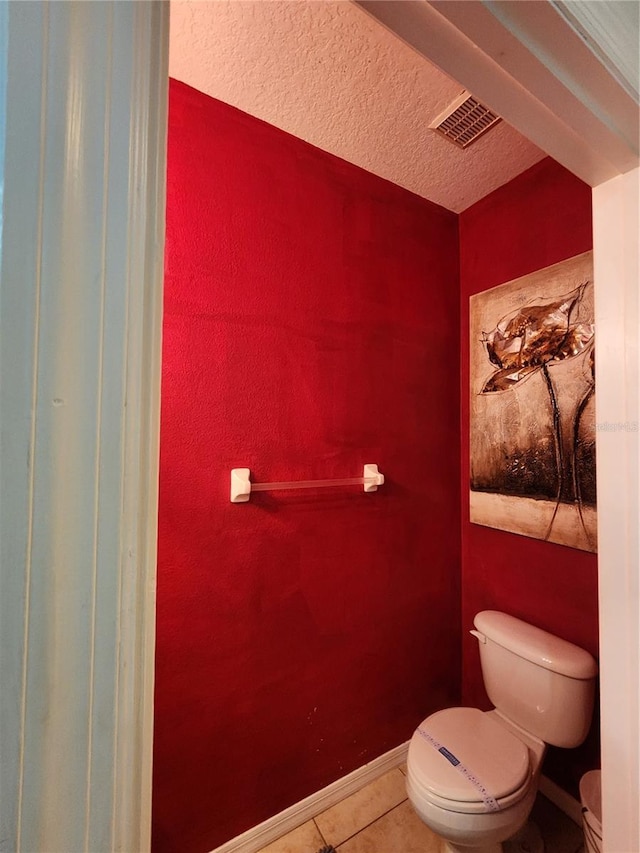 bathroom featuring tile patterned floors, a textured ceiling, and toilet