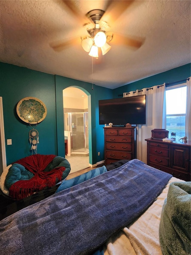 bedroom featuring carpet flooring, a textured ceiling, ceiling fan, and connected bathroom