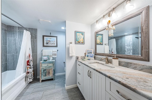 bathroom with a textured ceiling, vanity, and shower / tub combo