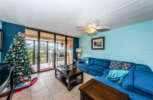 living room featuring light tile patterned floors, a textured ceiling, expansive windows, and ceiling fan