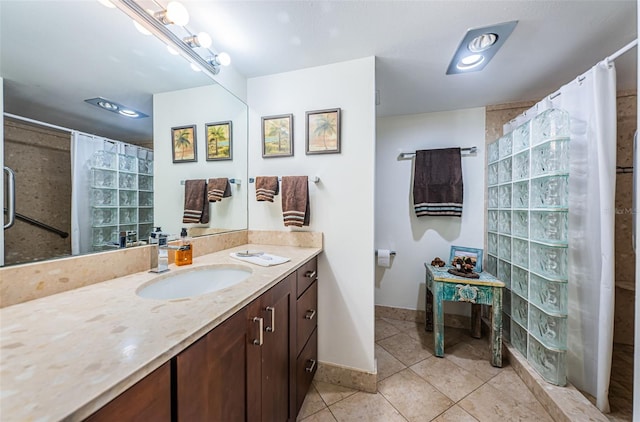 bathroom featuring tile patterned flooring, vanity, and walk in shower