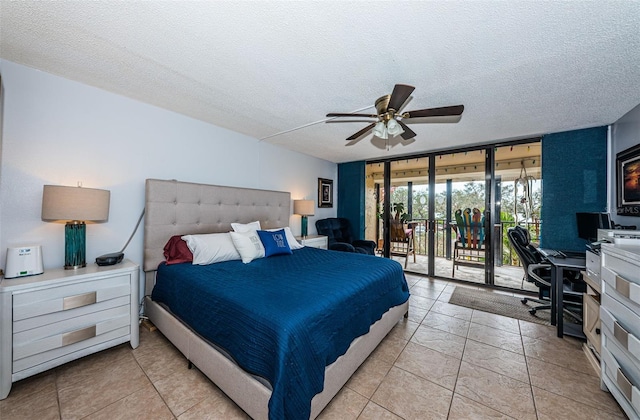 tiled bedroom featuring a textured ceiling, a wall of windows, access to outside, and ceiling fan