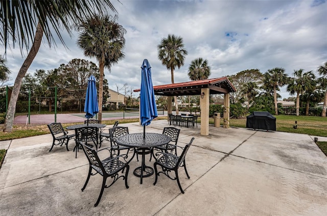 view of patio with tennis court and area for grilling