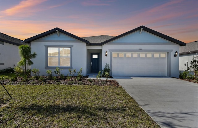 ranch-style house featuring a yard and a garage