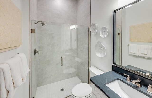 bathroom featuring vanity, toilet, and a shower with door