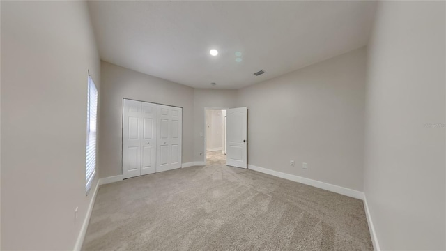 unfurnished bedroom with carpet flooring and a closet