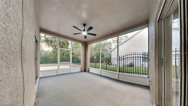 unfurnished sunroom featuring ceiling fan and a healthy amount of sunlight