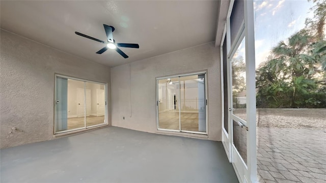 unfurnished sunroom featuring ceiling fan