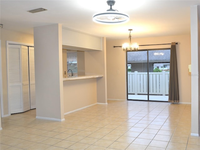 empty room with sink, an inviting chandelier, and light tile patterned flooring