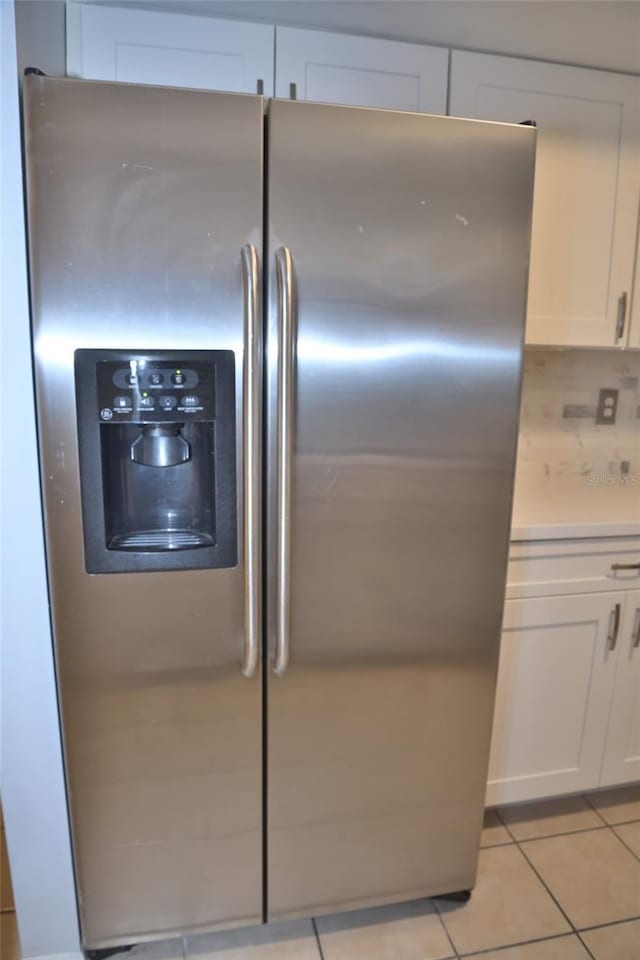 interior space with tasteful backsplash, white cabinetry, and stainless steel refrigerator with ice dispenser