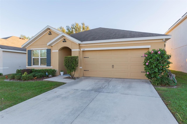 single story home with a garage and a front lawn