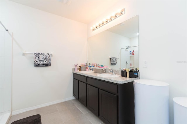 bathroom with a shower, tile patterned flooring, and vanity