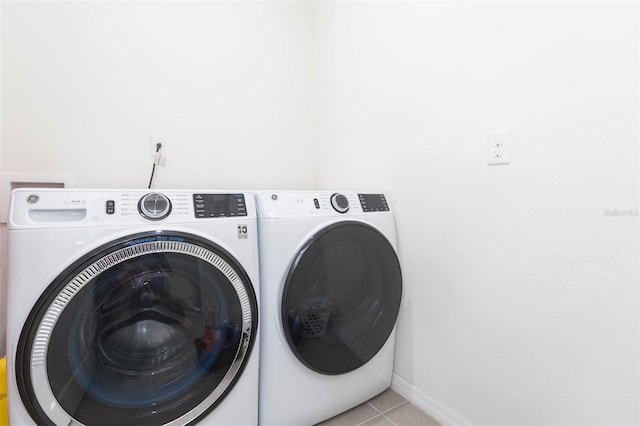 laundry area featuring washer and dryer and light tile patterned floors