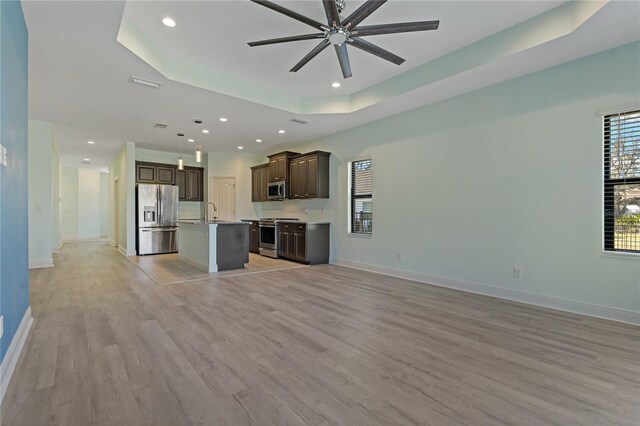 13584 Old Creek Ct, Parrish, FL 34219 - unfurnished living room with ceiling fan, light wood-style flooring, recessed lighting, a raised ceiling, and baseboards