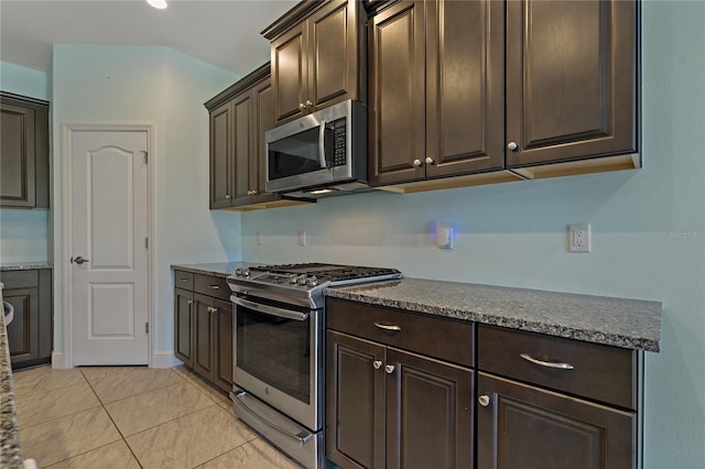 kitchen with light tile patterned floors, dark brown cabinetry, and stainless steel appliances