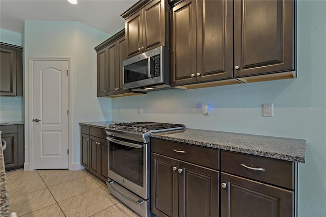 13584 Old Creek Ct, Parrish, FL 34219 - kitchen featuring stainless steel appliances, dark brown cabinets, light tile patterned floors, and dark stone counters