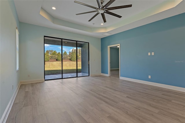 13584 Old Creek Ct, Parrish, FL 34219 - empty room featuring a tray ceiling, ceiling fan, light wood-style flooring, baseboards, and recessed lighting